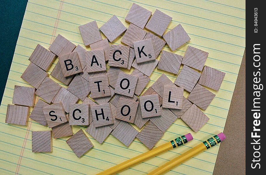 A piece of paper and pencils with letter blocks forming the sentence "back to school".
