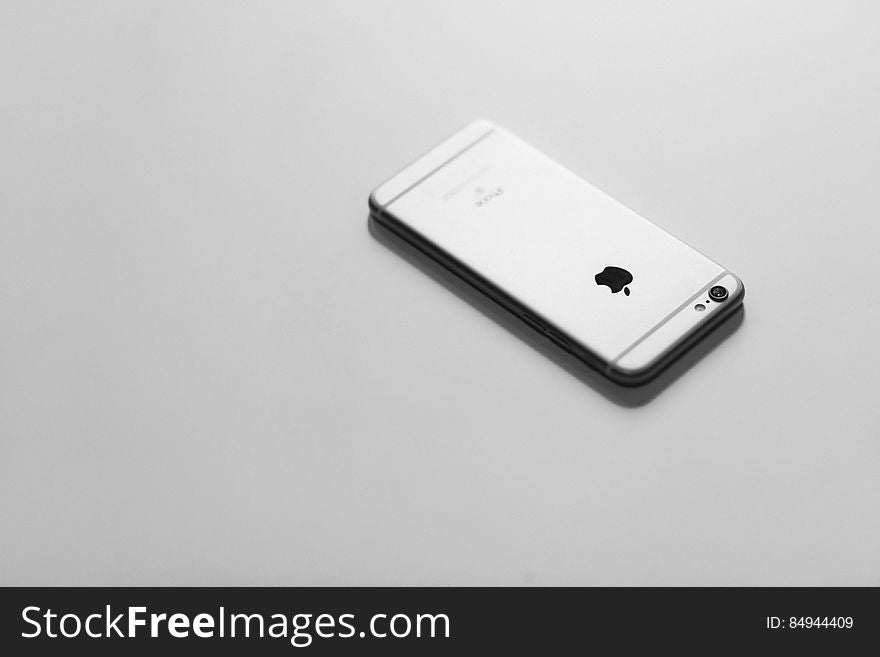 An Apple iPhone on gray surface.