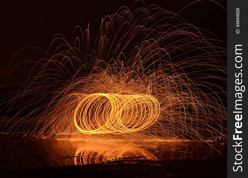 Lon exposure of a fire performance in the night with person spinning a burning object leaving trails.
