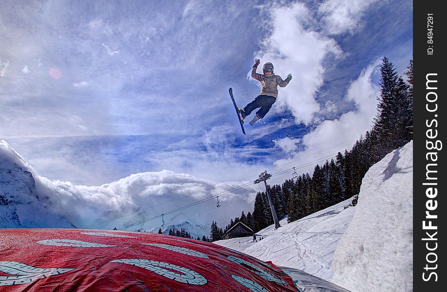 Ski jumper on alpine slopes against blue skies