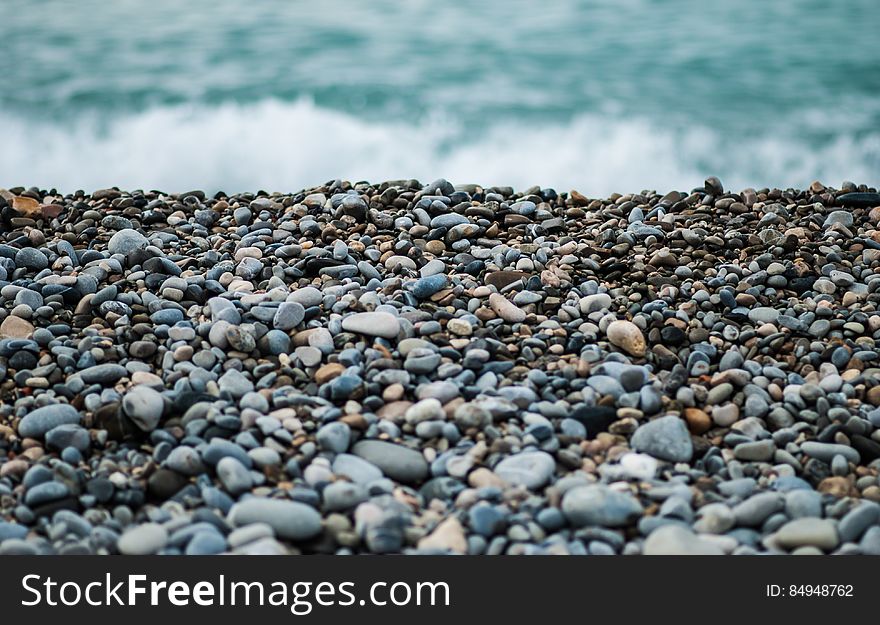 Pebbles On Seashore By Ocean