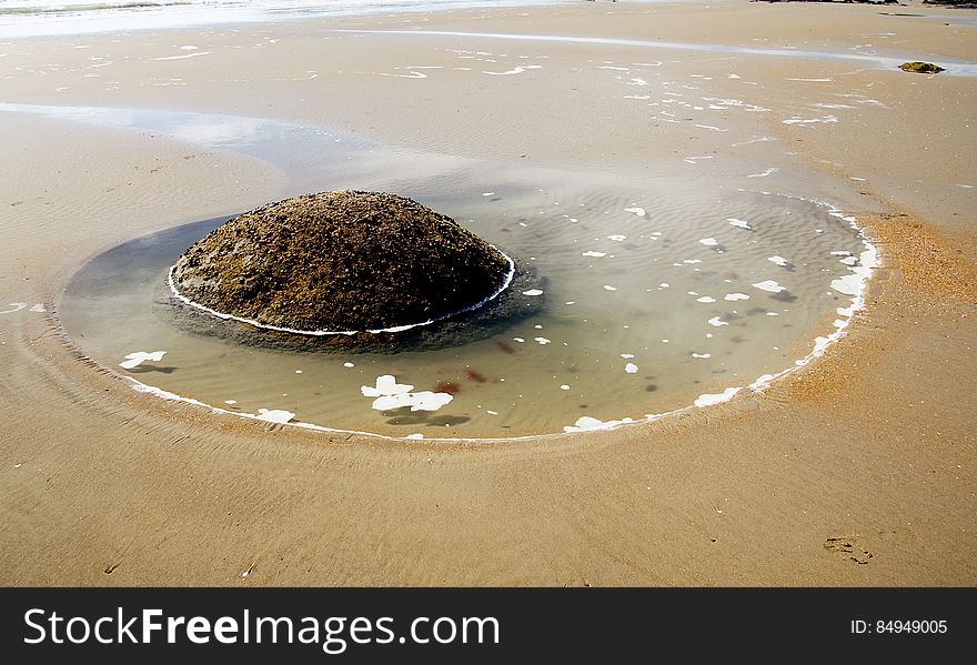 The Moeraki Boulders are situated on Koekohe Beach at a place named Kumara, midway between Hampden and Moeraki townships in North Otago. Access to them is gained by a small one-way side road, 1 mile north along the main road from Hillgrove railway station. The boulders are grey-coloured septarian concretions, which have been eroded out by wave action from the cliffs of soft, black mudstone that back the beach. In places, partially exposed concretions can be seen in the cliffs. They originally formed on the sea floor when the mudstone was accumulating during the early Tertiary period some 60 million years ago. The Moeraki Boulders are situated on Koekohe Beach at a place named Kumara, midway between Hampden and Moeraki townships in North Otago. Access to them is gained by a small one-way side road, 1 mile north along the main road from Hillgrove railway station. The boulders are grey-coloured septarian concretions, which have been eroded out by wave action from the cliffs of soft, black mudstone that back the beach. In places, partially exposed concretions can be seen in the cliffs. They originally formed on the sea floor when the mudstone was accumulating during the early Tertiary period some 60 million years ago.