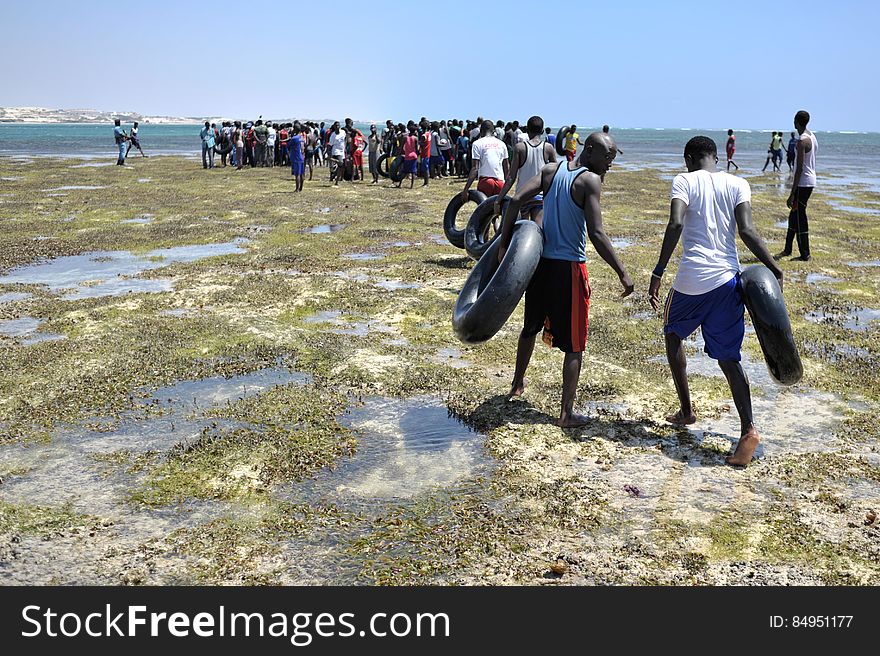 Young men carry old inner tubes they&#x27;ve used to get to a sandbank off of Lido beach in the Somali capital of Mogadishu on January 31. The Mogadishu lifeguards, consisting entirely of a volunteer force of fisherman, began patrolling Lido beach in September 2013 after a spate of drownings. Mogadishu&#x27;s beaches have become a popular destination for the city&#x27;s residents since al Shabab withdrew the majority of its militants from the city in 2011. AU UN IST PHOTO / Tobin Jones. Young men carry old inner tubes they&#x27;ve used to get to a sandbank off of Lido beach in the Somali capital of Mogadishu on January 31. The Mogadishu lifeguards, consisting entirely of a volunteer force of fisherman, began patrolling Lido beach in September 2013 after a spate of drownings. Mogadishu&#x27;s beaches have become a popular destination for the city&#x27;s residents since al Shabab withdrew the majority of its militants from the city in 2011. AU UN IST PHOTO / Tobin Jones