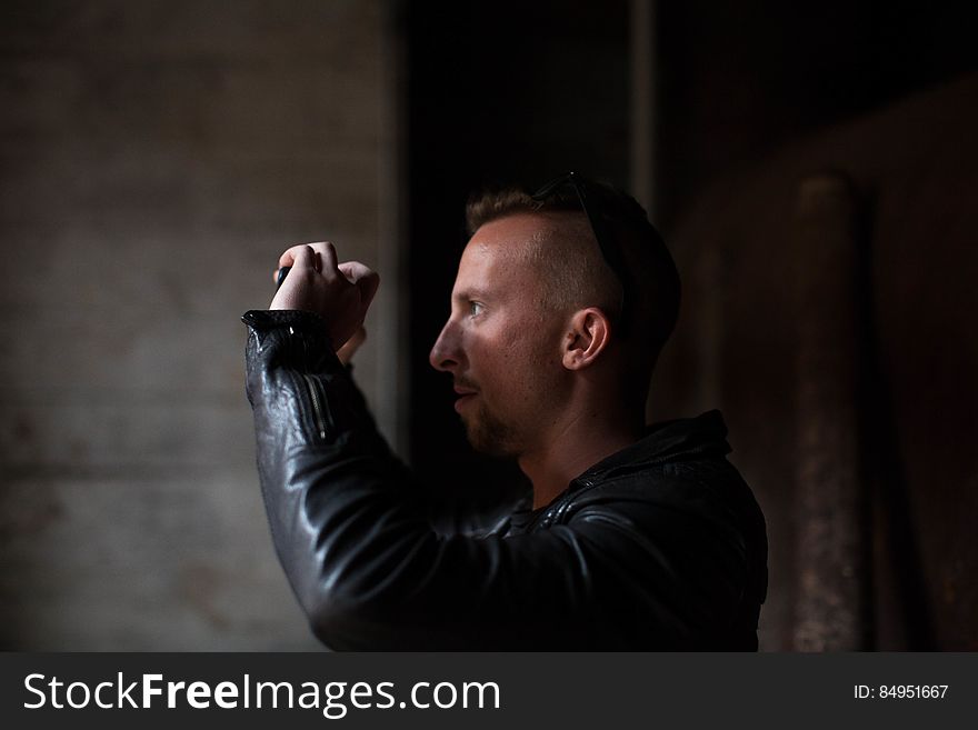 Man In Black Jacket Holding Camera