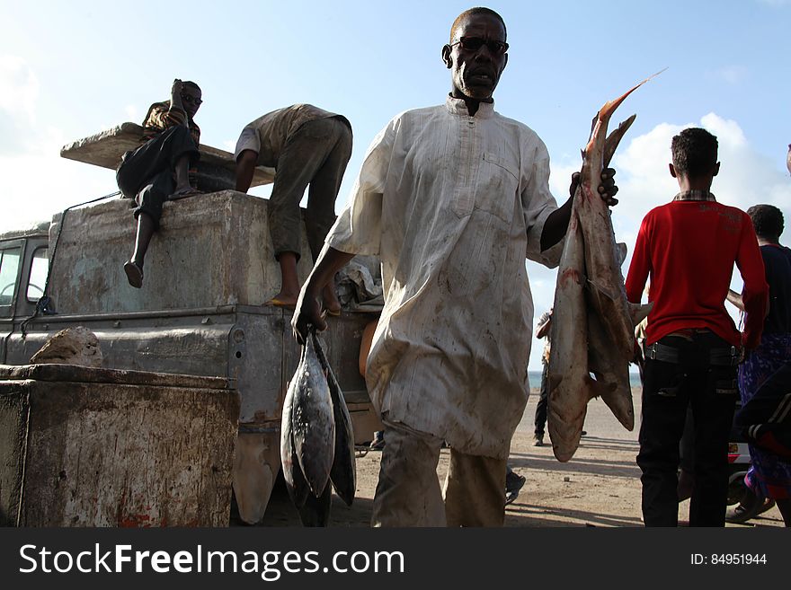 A Somali fisherman carries fish from a car in Hamar Weyn distrct&#x27;s fish market. Mogadishu, Somalia. May 22, 2013. AU UN IST PHOTO / Ilyas A. Abukar. A Somali fisherman carries fish from a car in Hamar Weyn distrct&#x27;s fish market. Mogadishu, Somalia. May 22, 2013. AU UN IST PHOTO / Ilyas A. Abukar