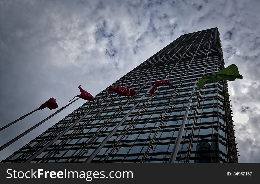 A tall office building with flags in front.