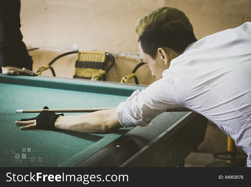A man plans a shot in a pool game. A man plans a shot in a pool game.