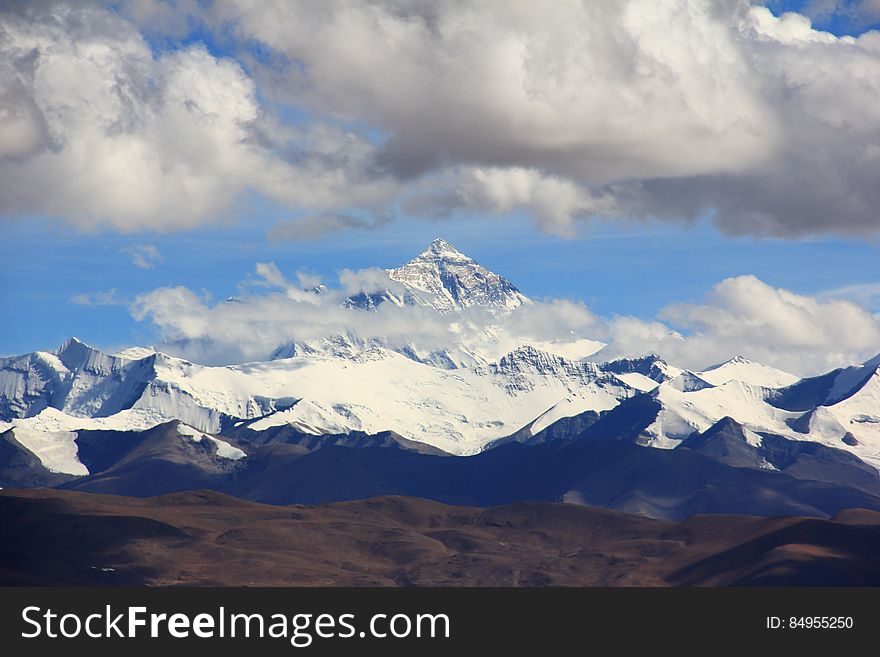 Snow Filled Mountain Under Cloudy Sky during Daytime