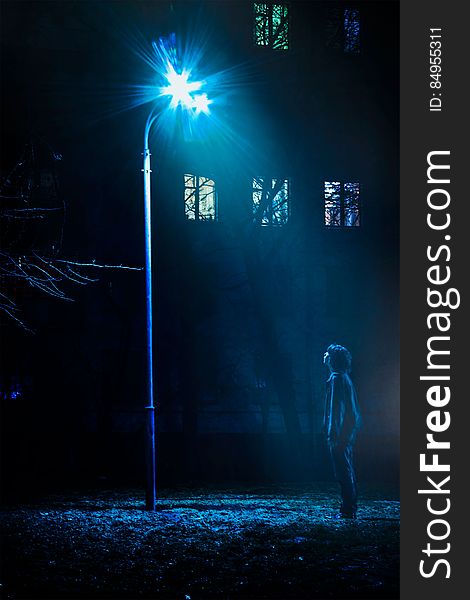 Man Standing In Front Of Street Light Turned On