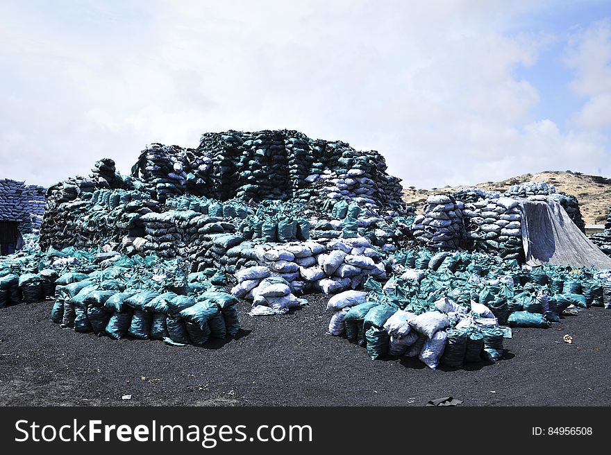 Bags of charcoal lie stockpiled on the edge of Kismayo city. The charcoal trade remains the city&#x27;s largest industry, but its future remains uncertain due to a UN embargo which forbids its export. AU-UN IST PHOTO / TOBIN JONES. Bags of charcoal lie stockpiled on the edge of Kismayo city. The charcoal trade remains the city&#x27;s largest industry, but its future remains uncertain due to a UN embargo which forbids its export. AU-UN IST PHOTO / TOBIN JONES.