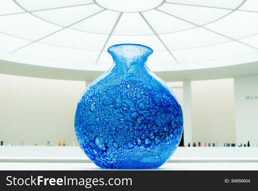 A close up of a blue glass vase indoor. A close up of a blue glass vase indoor.