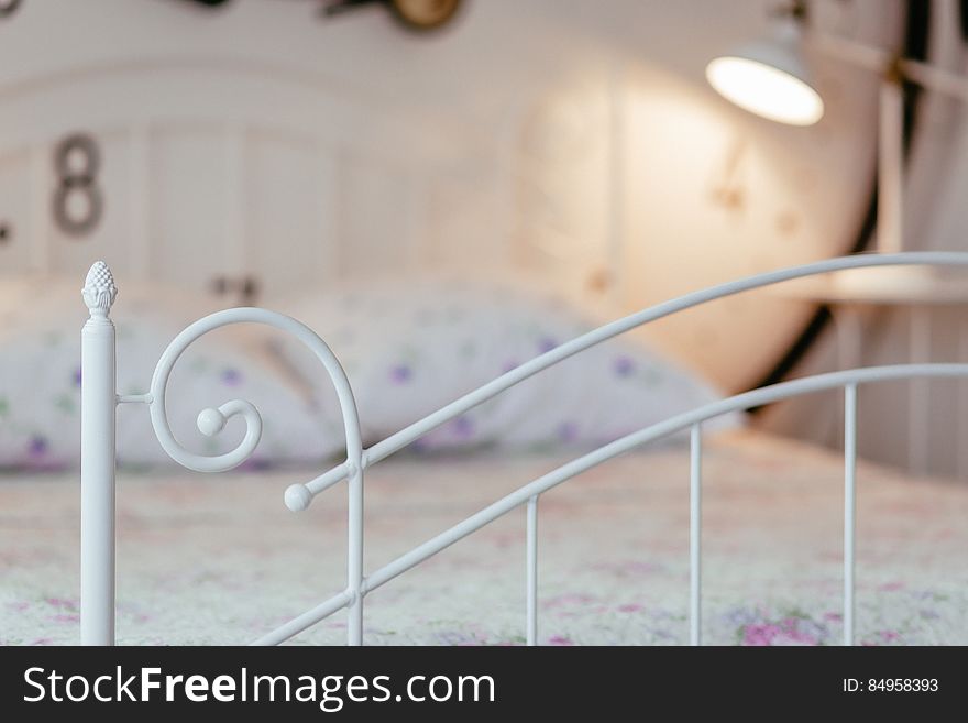 A close up of a bed in the bedroom with white metal frame. A close up of a bed in the bedroom with white metal frame.