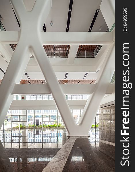 Large hall in modern building with white ceiling supports and reflection.