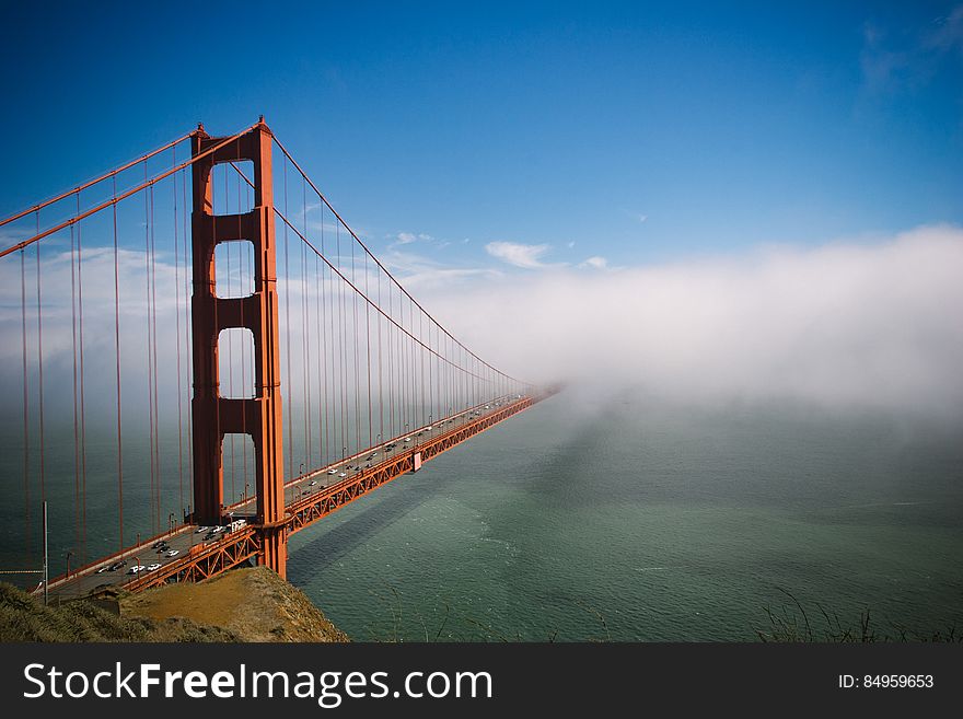 View of the Golden Gate Bridge in San Francisco, California, with a low fog obscuring the far side of the span.