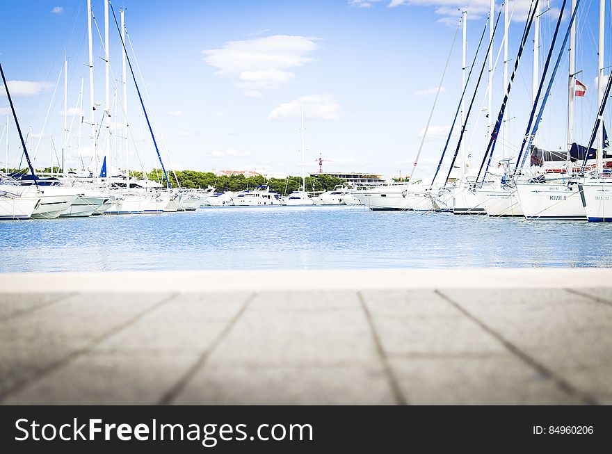 A view across a harbor with yachts and sailboats moored at the dock. A view across a harbor with yachts and sailboats moored at the dock.