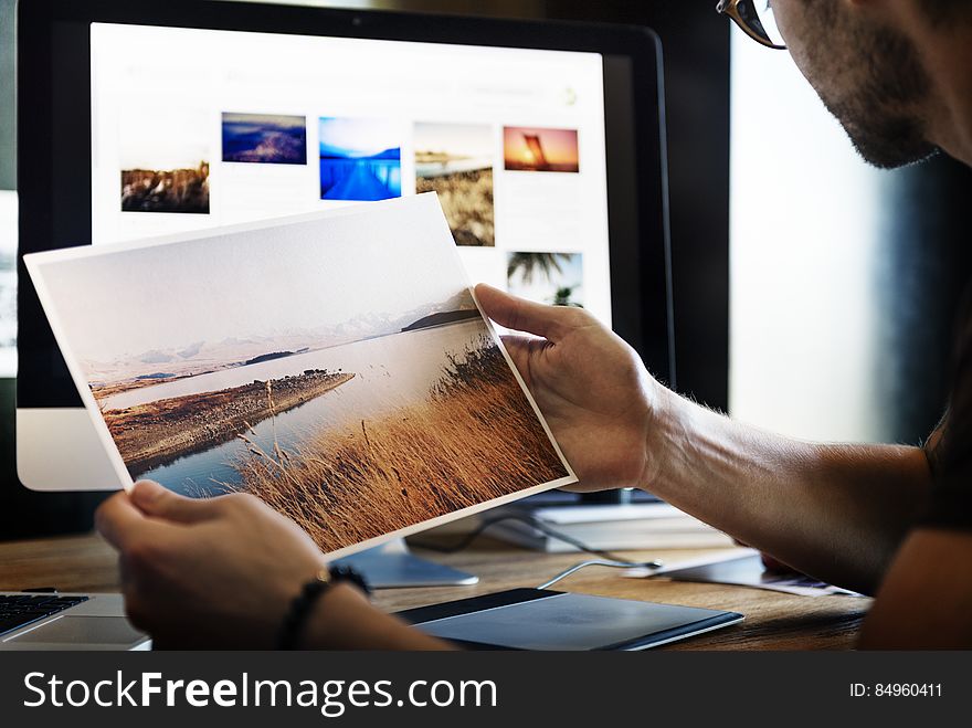 A photographer or graphics designer looking at printed photographs. A photographer or graphics designer looking at printed photographs.