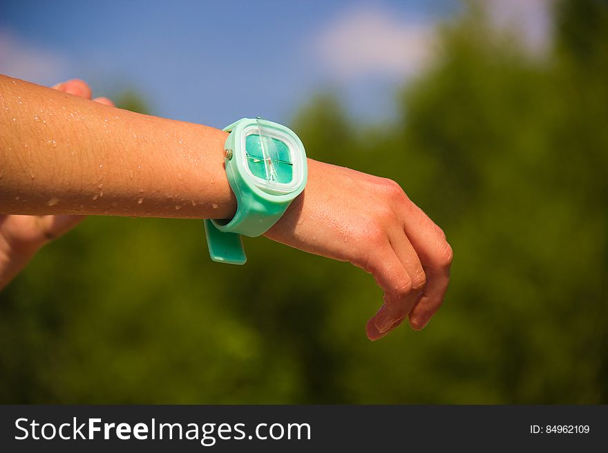 Wet arm of a person outdoors wearing waterproof wristwatch. Wet arm of a person outdoors wearing waterproof wristwatch.