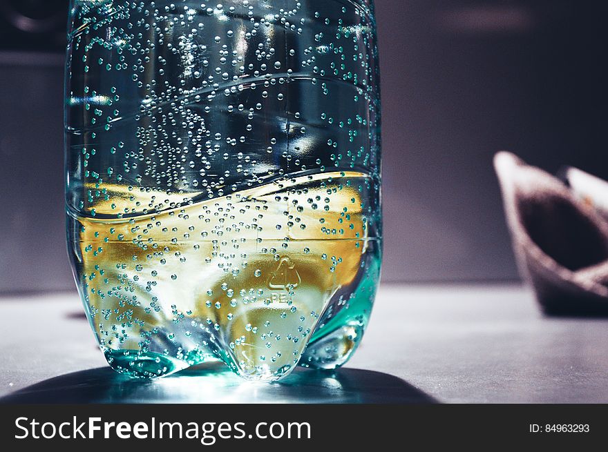 A close up of a water bottle on the table with bubbles rising. A close up of a water bottle on the table with bubbles rising.