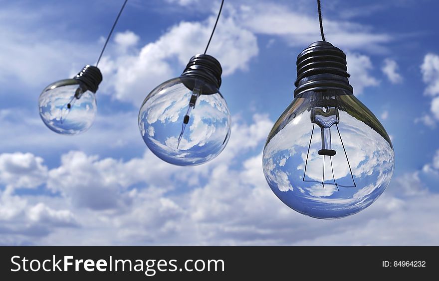 An illustration of light bulbs against blue sky.