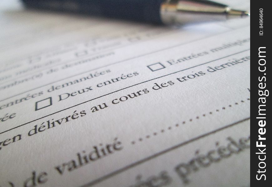 A close up of a formal document in French and a pen on it. A close up of a formal document in French and a pen on it.