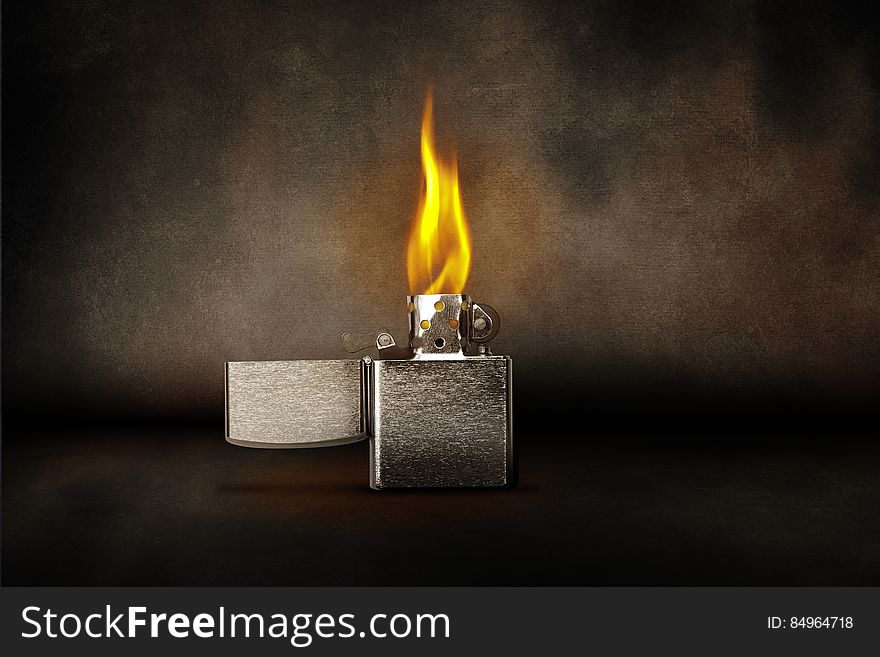 A burning zippo lighter and smoke around.