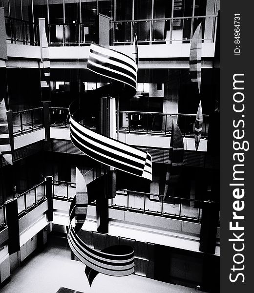 A black and white photo of a spiral structure inside a building. A black and white photo of a spiral structure inside a building.
