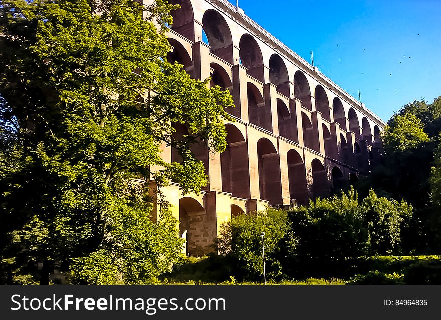 A building with arched openings and greenery around.