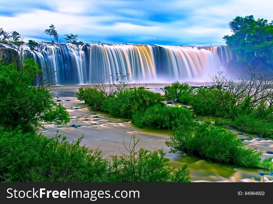 Water Falls Surrounding Green Grass during Daytime