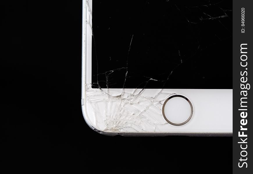 An Apple iPhone with shattered front glass. An Apple iPhone with shattered front glass.