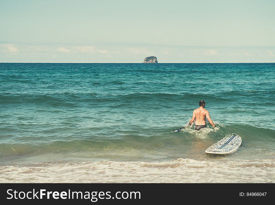 Male Surfer With Surfboard In Ocean