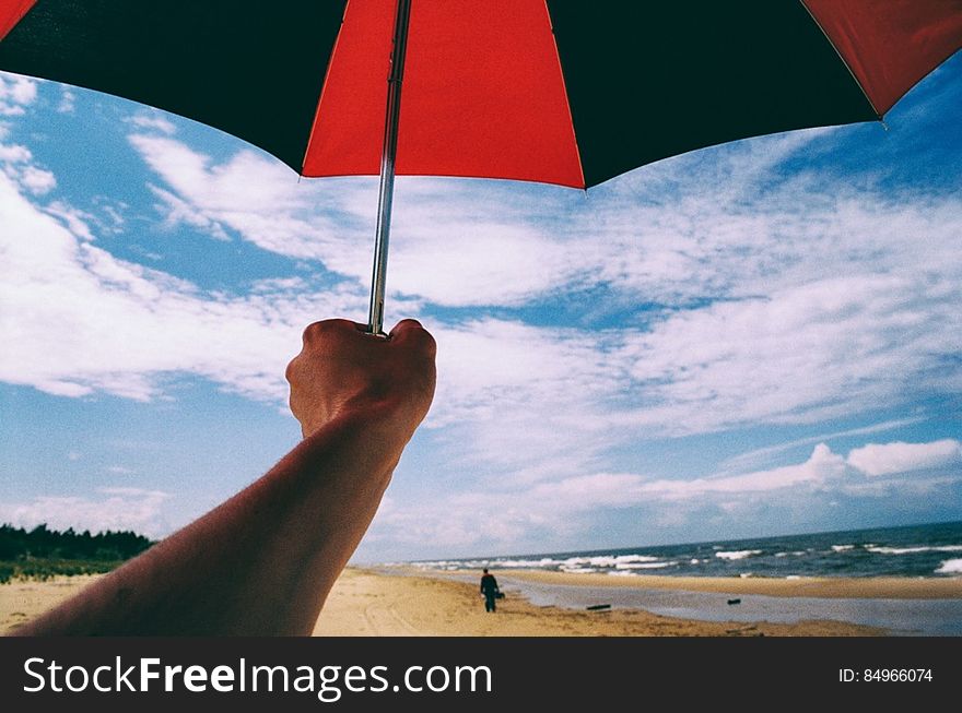 Umbrella In Hand On A Beach