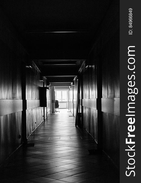 Black and white view looking down long empty hallway. Black and white view looking down long empty hallway.