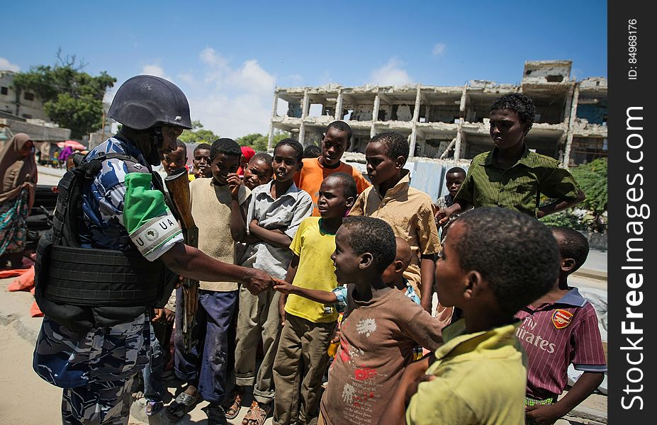 A Ugandan police officer serving as part of a Formed Police Unit &#x28;FPU&#x29; with the African Union Mission in Somalia &#x28;AMISOM&#x29; shakes hands with a group of Somali children during a foot patrol in the Kaa&#x27;ran district of the Somali capital Mogadishu 09 November 2012. AMISOM&#x27;s FPUs are working with their counterparts in the Somali Police Force &#x28;SPF&#x29; in helping to provide security in Mogadishu in addition to training and mentoring the SPF on policing techniques and practises. AU-UN IST PHOTO / STUART PRICE. A Ugandan police officer serving as part of a Formed Police Unit &#x28;FPU&#x29; with the African Union Mission in Somalia &#x28;AMISOM&#x29; shakes hands with a group of Somali children during a foot patrol in the Kaa&#x27;ran district of the Somali capital Mogadishu 09 November 2012. AMISOM&#x27;s FPUs are working with their counterparts in the Somali Police Force &#x28;SPF&#x29; in helping to provide security in Mogadishu in addition to training and mentoring the SPF on policing techniques and practises. AU-UN IST PHOTO / STUART PRICE.