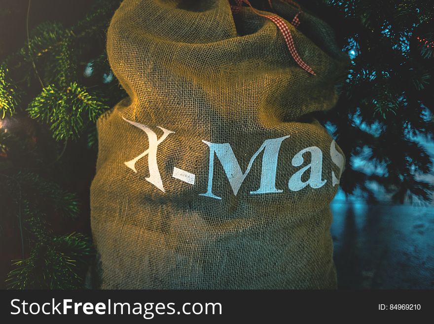 A Christmas gift bag with the word "X-mas" written on it.