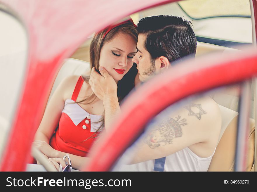 A couple sitting in an antique car. A couple sitting in an antique car.