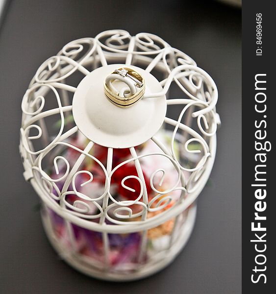 A wedding ring on a white lantern with colorful petals. A wedding ring on a white lantern with colorful petals.