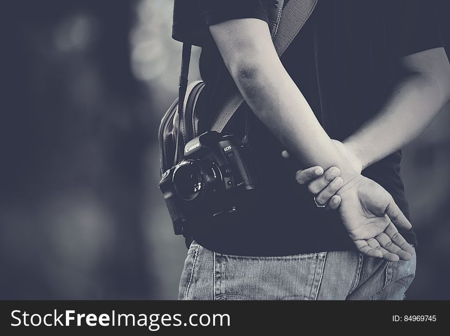 A photographer with a camera holding hands behind back. A photographer with a camera holding hands behind back.