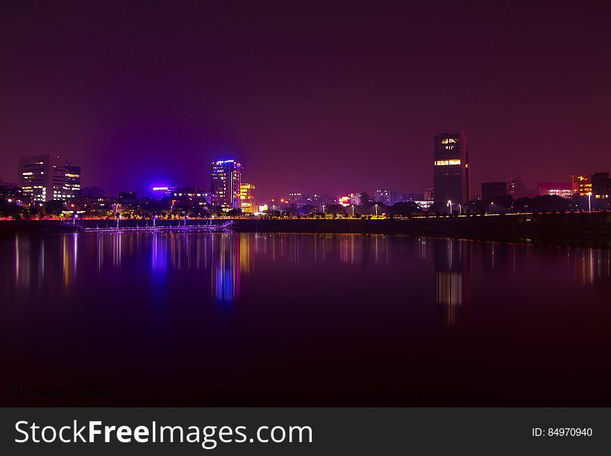 A city skyline at night reflecting from the water. A city skyline at night reflecting from the water.