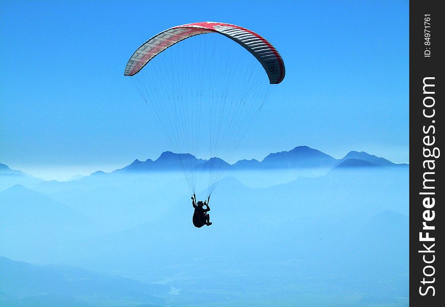 Person Doing Paragliding Above Clouds During Daytime