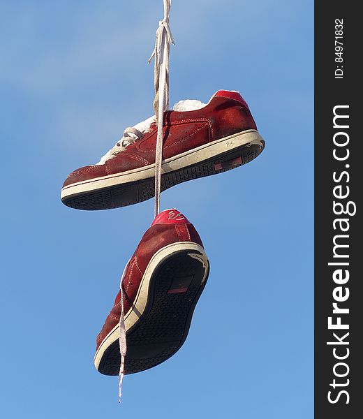 Red and White Hanging Sneakers during Daytime