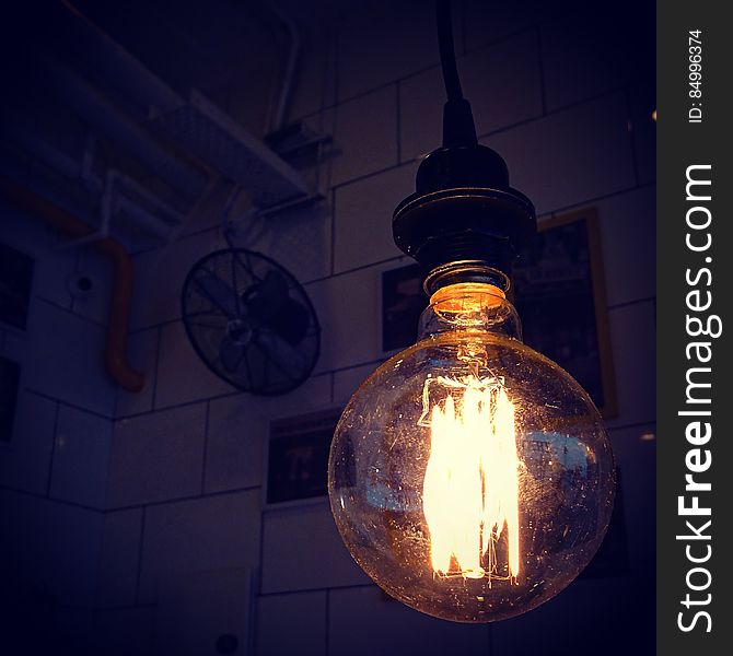 An old incandescent light bulb hanging from the ceiling.