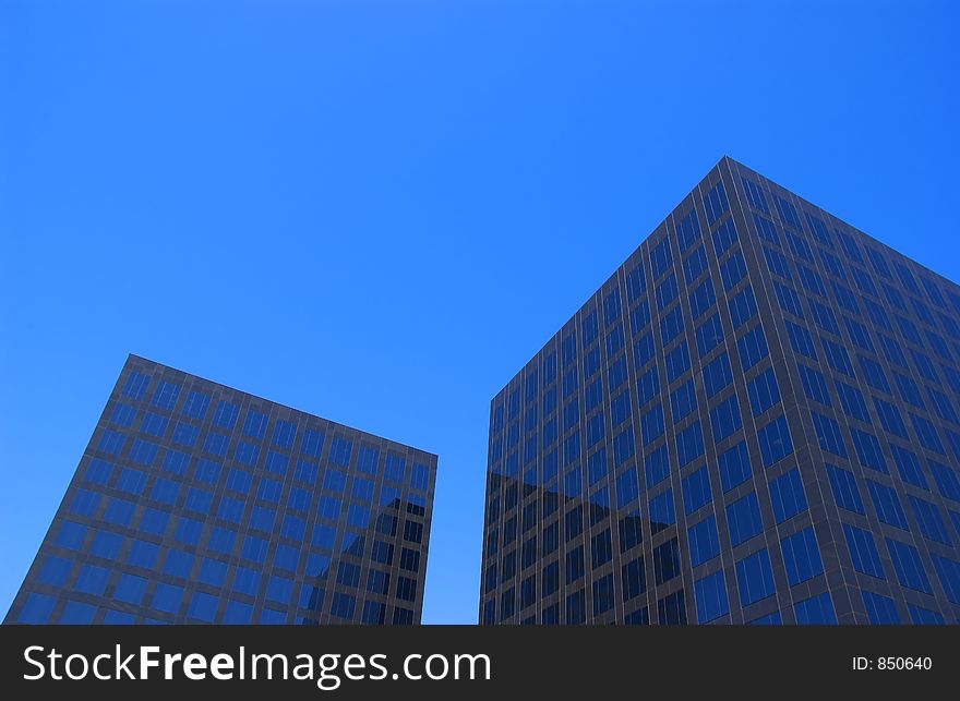 Two black corporate buildings and blue sky