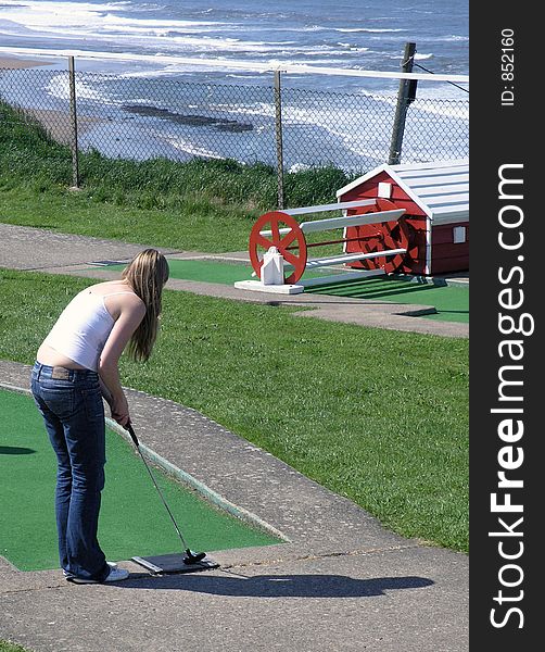 Woman playing crazy golf in Whitby, North Yorkshire. Woman playing crazy golf in Whitby, North Yorkshire.