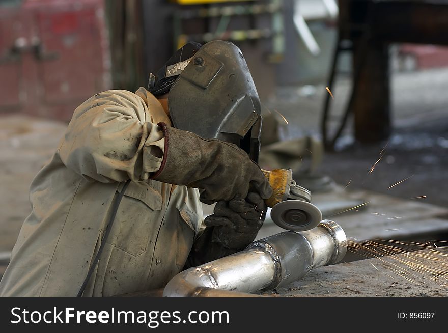 Worker grinding pipe. Worker grinding pipe