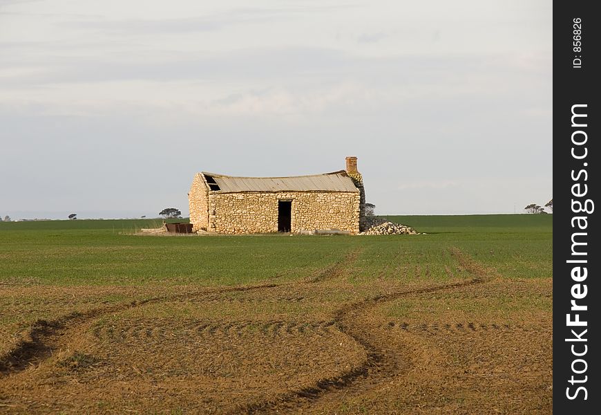 An old farmhouse in the middle of a farmers crop. An old farmhouse in the middle of a farmers crop