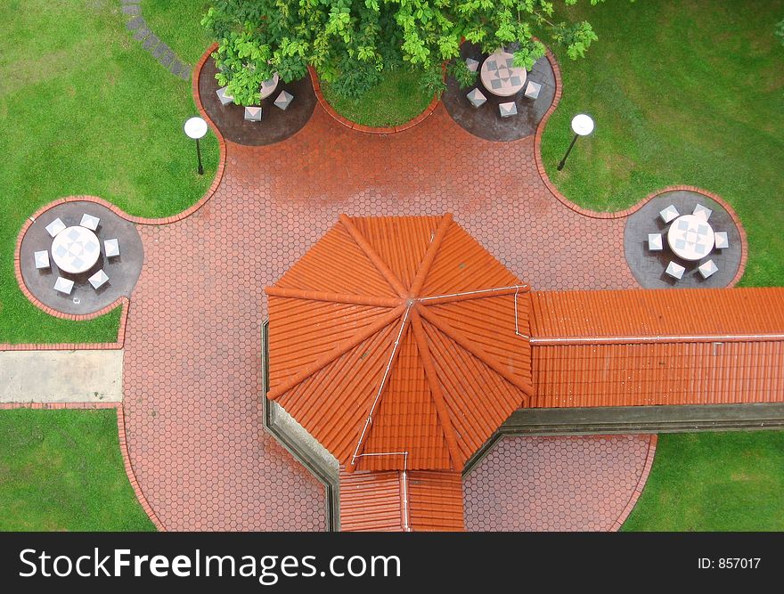 Top view of a pavillion with tables and chairs forming a pattern around it. Top view of a pavillion with tables and chairs forming a pattern around it