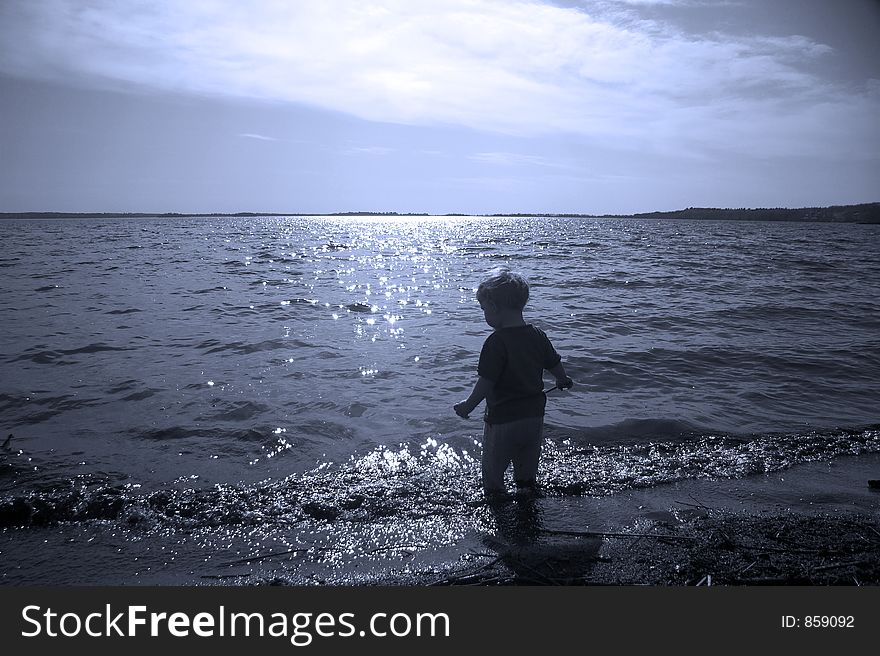 Small child entering a lake. Small child entering a lake.