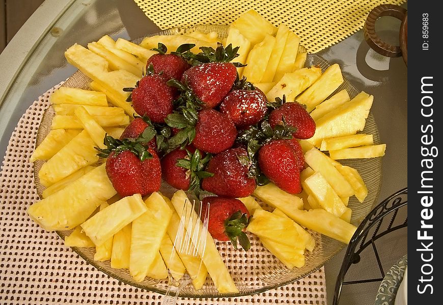 A platter of fresh strawberries and cut pineapple. A platter of fresh strawberries and cut pineapple.