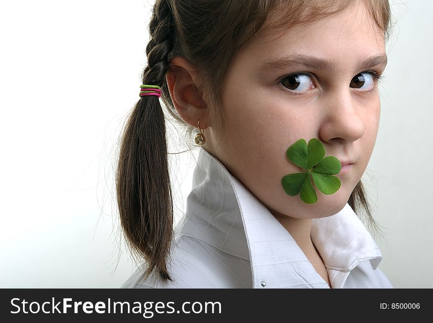 Little girl holding a clover in corner of her mouth. Little girl holding a clover in corner of her mouth