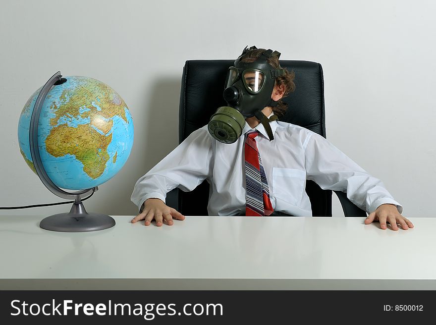 Businessman with gas mask on face looking at earth globe. Businessman with gas mask on face looking at earth globe